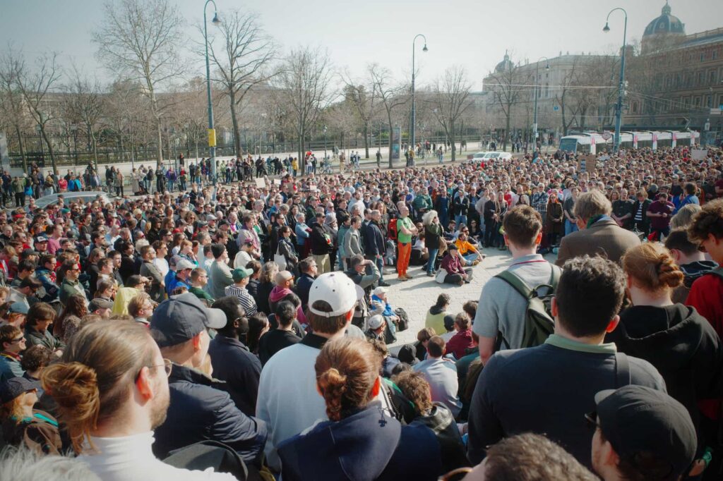 Blick vom Parlament Wien hinunter auf ein eine große Gruppe Menschen. Demonstration.